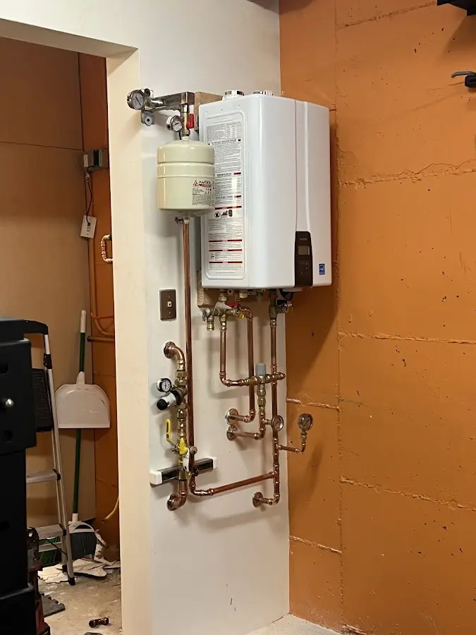 Plumbing technician inspecting water heater connections in Lugoff